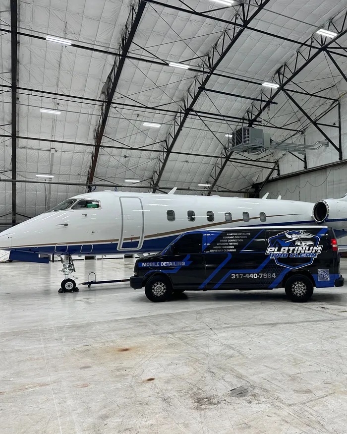 The Platinum Pro Clean detailing van beside a private jet in an Indiana hangar