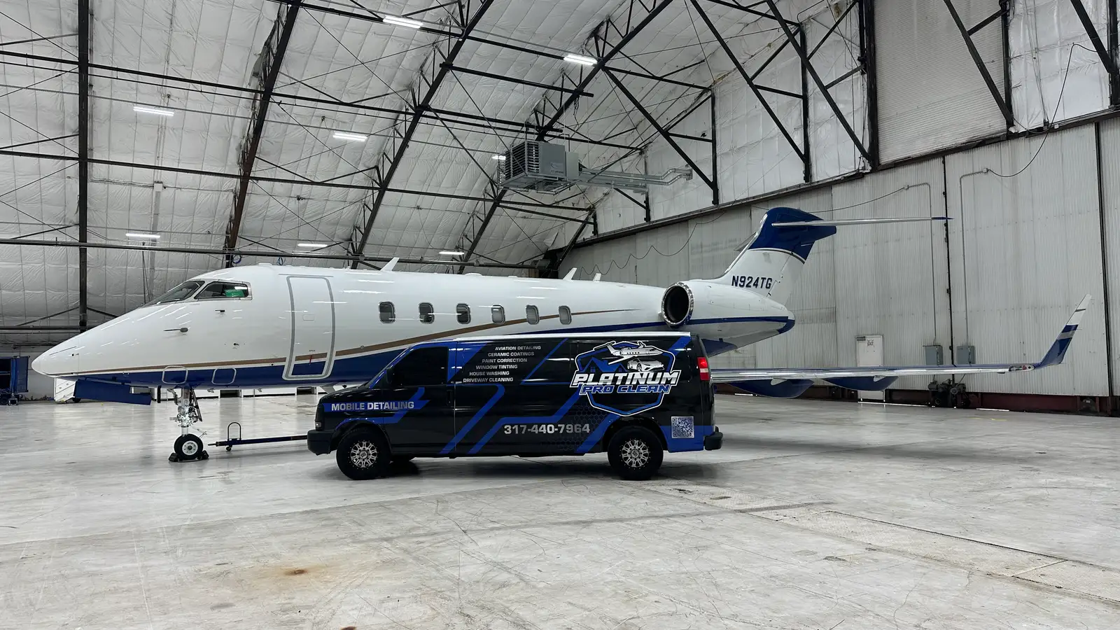 The Platinum Pro Clean van beside a private jet inside an Indiana hangar